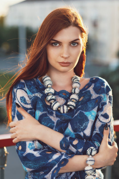 一个年轻漂亮的女孩直视着镜头的肖像。模特在温暖阳光明媚的晚上摆姿势图片下载