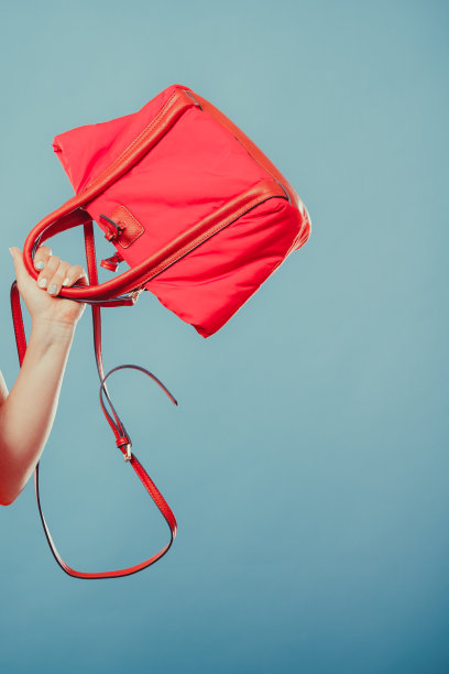 特写的时尚女人的手与红色手提包。图片下载