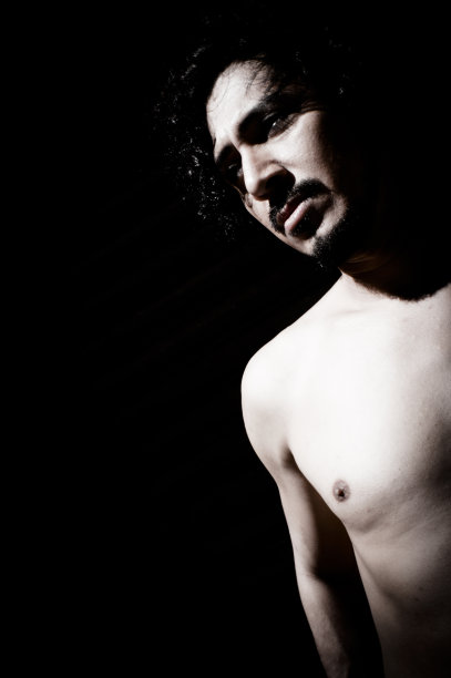 有胡子和黑色卷发的拉丁男子的肖像。赤裸的身体图片下载