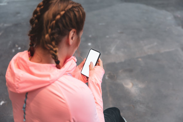 女人看着她的手机穿着运动服图片下载