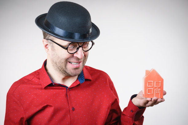 戴着滑稽眼镜的男人扶着房子图片下载