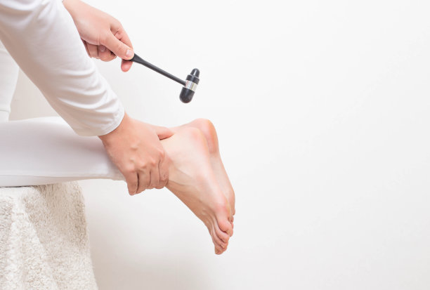 神经科医生用神经锤检查跟腱反射。检查胫神经和脊柱椎间疝的存在，复制空间图片下载
