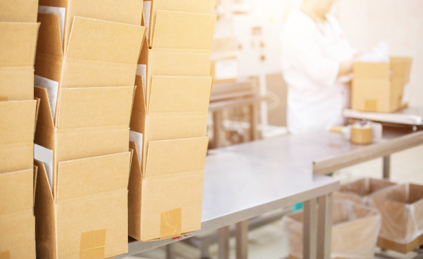 一个奶牛厂的工人把黄油和涂了光的凝乳放进盒子里。生产乳制品，用于生产、出口图片下载