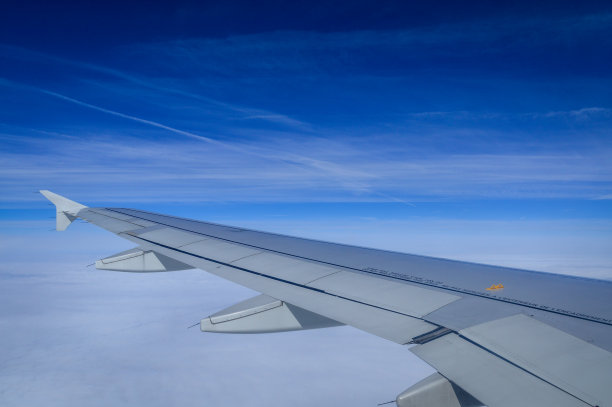 从带有飞机机翼和蓝天的飞机的舷窗俯瞰云层图片下载