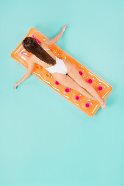 全身后视图高角度以上平躺垂直照片美丽的女士游泳床垫移动手臂海边方向穿泳衣孤立的柔和的蓝绿色背景图片下载