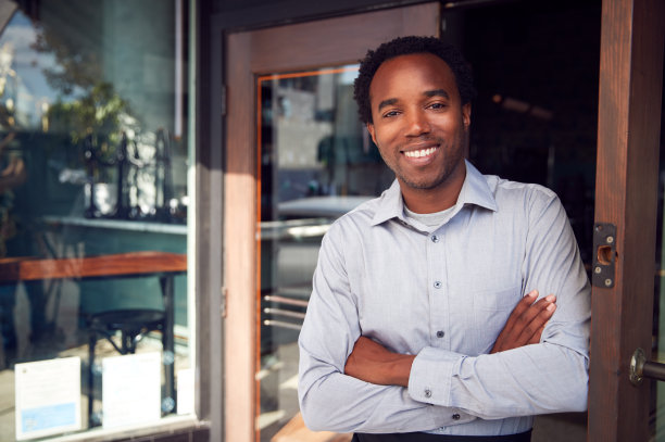 创业咖啡店或餐厅的男老板站在门口的肖像图片下载