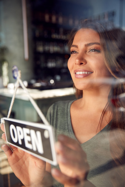 女性业主的启动咖啡店或餐厅转身打开门上的标志图片下载