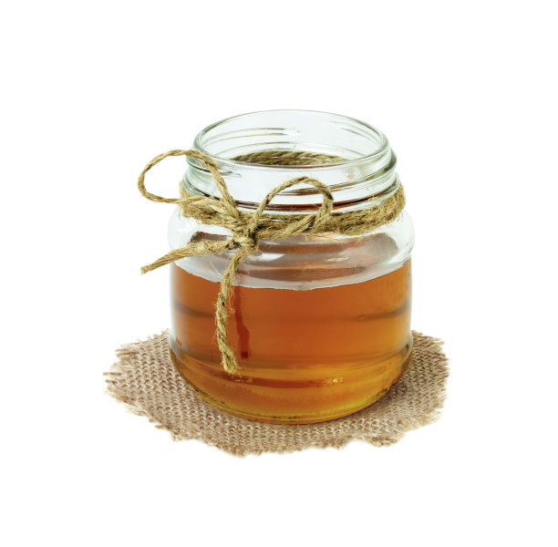 玻璃瓶中的蜂蜜被隔离在白色背景上图片下载