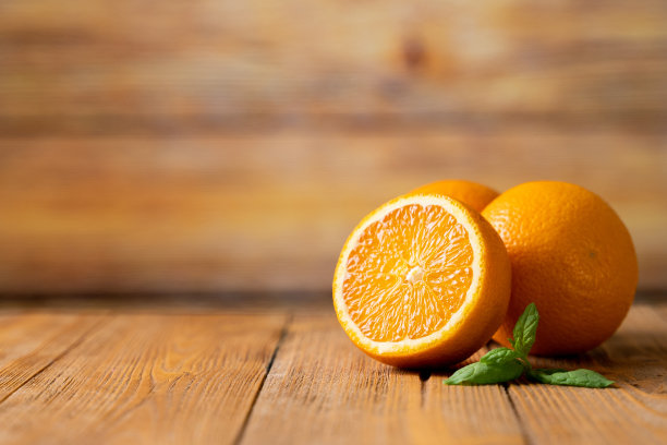 三个新鲜的橘子放在木桌上图片下载