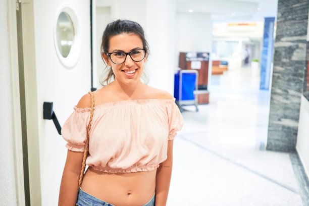 美丽的女孩在酒店大厅里快乐的微笑图片下载