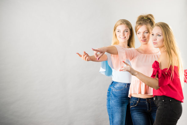 三位时尚女性指着图片下载