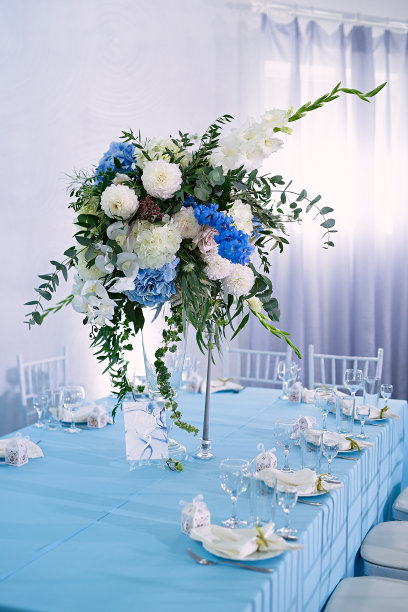 花坛上的花瓶立在节日的桌子上，桌子是预留的，桌子上铺着蓝色的台布图片下载