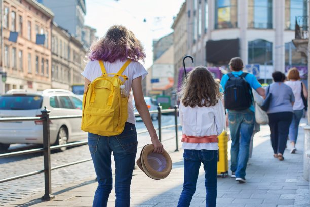人们走在城市的街道上，人行道上，路上有移动的汽车图片下载