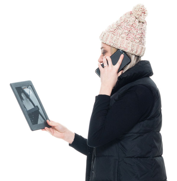 白种年轻女性无袖穿着裤子站在白色背景前使用触摸屏图片下载