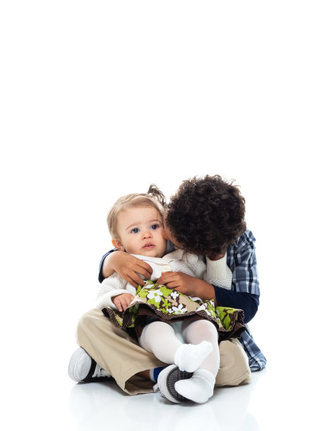 哥哥坐在白色背景前的地板上图片下载