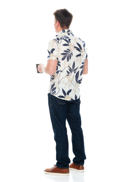 白人男性站在白色背景下穿着牛仔裤，拿着咖啡杯图片下载