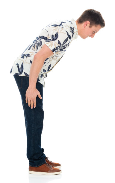 穿着牛仔裤的白人年轻男子在白色背景前鞠躬图片下载