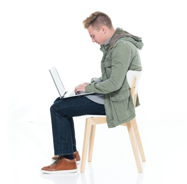 白人少年坐在白色背景下穿着运动夹克，使用笔记本电脑图片下载