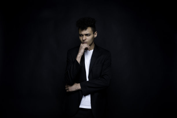 非裔美国青年潮男穿着t恤站在黑色背景前图片下载