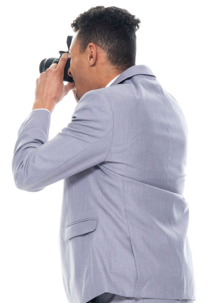 非洲裔年轻男性游客站在白人背景前，拿着相机图片下载