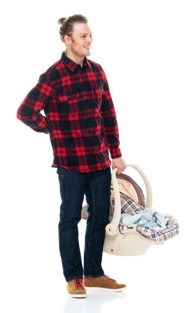 白种人婴儿-人类年龄站在白色背景穿着格子衬衫和持有汽车安全座椅图片下载