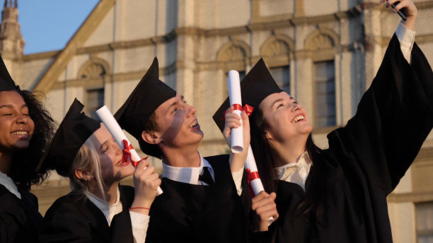 混血儿毕业时穿着黑色传统长袍，戴着帽子图片下载