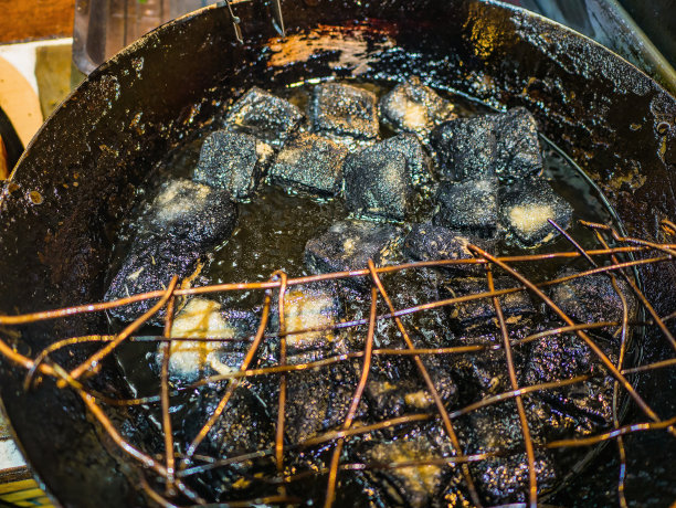 黑臭豆腐在中国凤凰古城的锅里煎。凤凰古城或凤凰县是中国湖南省的一个县图片下载