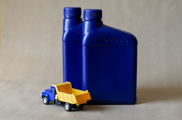 两个塑料罐，车油和一个玩具倾卸卡车。图片下载