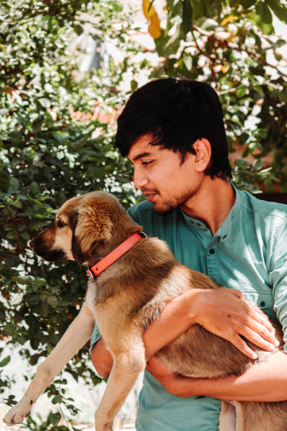 一个印度人抱着小狗的肖像图片下载