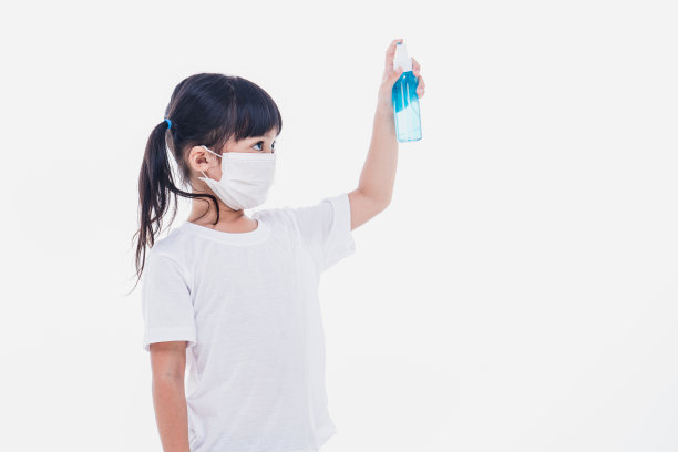 可爱的亚洲女孩戴着口罩，用酒精洗手，以防止在白色背景下传播疾病。预防流感病毒传播冠状病毒感染或污染图片下载