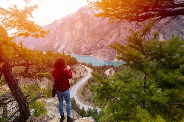 冒险的女孩在加拿大山区风景优美的道路上拍照图片下载