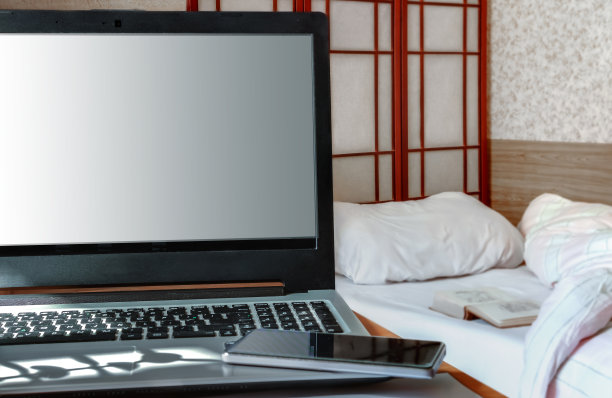 卧室里的工作场所用白色笔记本电脑屏幕写着“在家工作”的信息图片下载