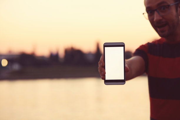 现代人在河边使用手机。图片下载