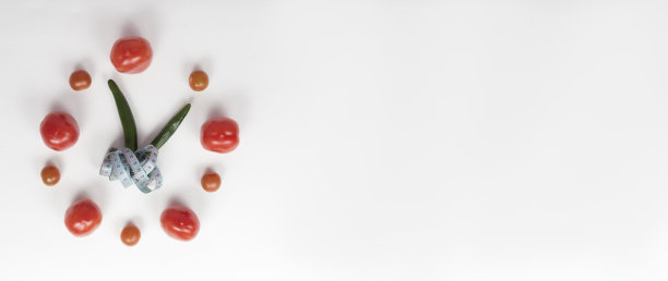 蔬菜、西红柿和辣椒的排列就像白色背景上的时钟。饮食，健康，按时吃饭。健康的食物图片下载
