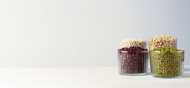 碗各种豆类:鹰嘴豆，扁豆，绿豆，红豆和白豆在灰色的背景与复制空间。横幅图片下载