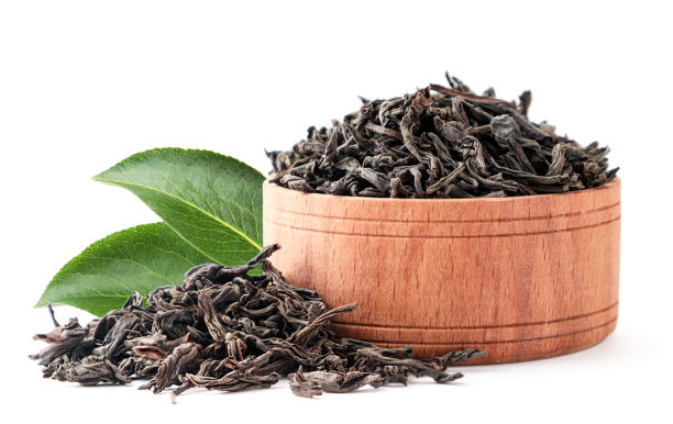 红茶装在木盘子里，绿叶在白色的背景上。孤立的图片下载