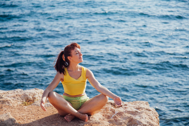 那个女孩坐在海边的悬崖上练瑜伽图片下载