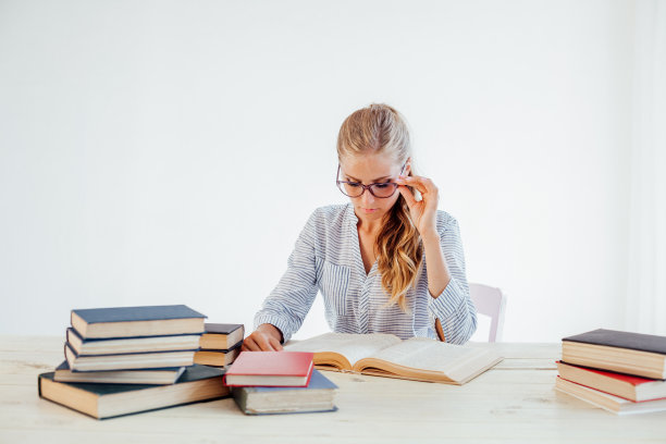 一个漂亮的金发女商人的肖像在桌子上教书图片下载