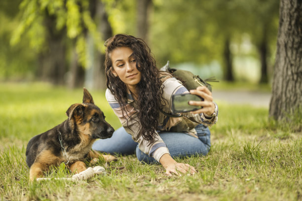 一个女人和她的狗在用手机自拍图片下载