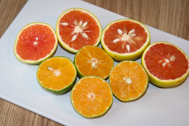 漂亮的柠檬和葡萄柚在砧板上切成两半。图片下载