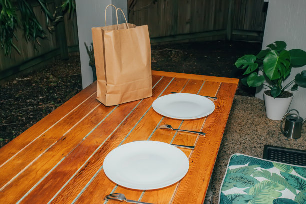 从餐厅送来的印度菜上晚餐的男人。桌上放着美味食物的塑料容器图片下载