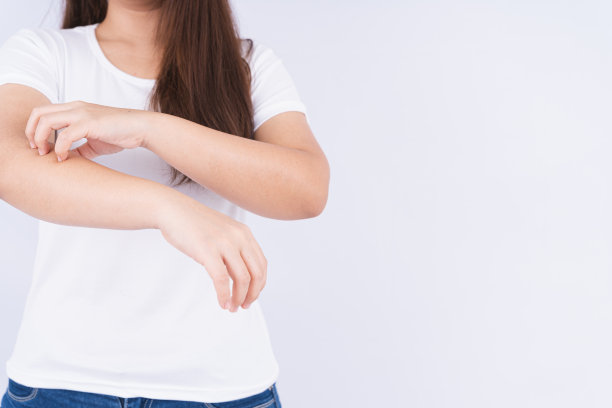 女性抓她的手臂在白色的背景与复制空间。医疗、保健为广告概念。图片下载