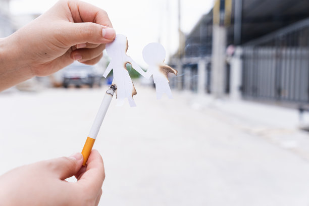 家庭成员被香烟破坏的剪纸。吸烟破坏家庭观念。在世界烟草日戒烟。图片下载