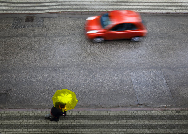 一个男人拿着一把黄色雨伞在移动的模糊动态图片图片下载
