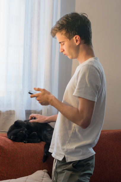 在新冠肺炎流行期间，年轻人在家里通过电话学习网络课程图片下载