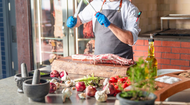 酋长正在为美味的晚餐准备羊排肉图片下载