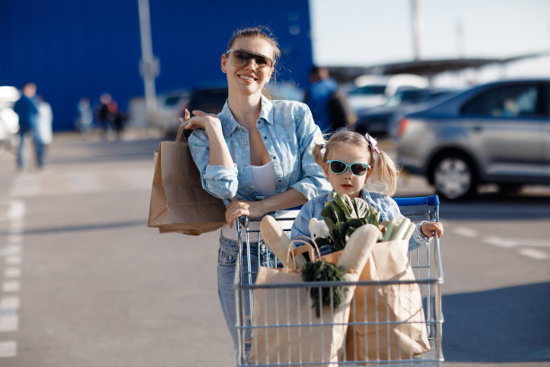 小女孩和她的妈妈购物后在超市附近的包装产品图片下载