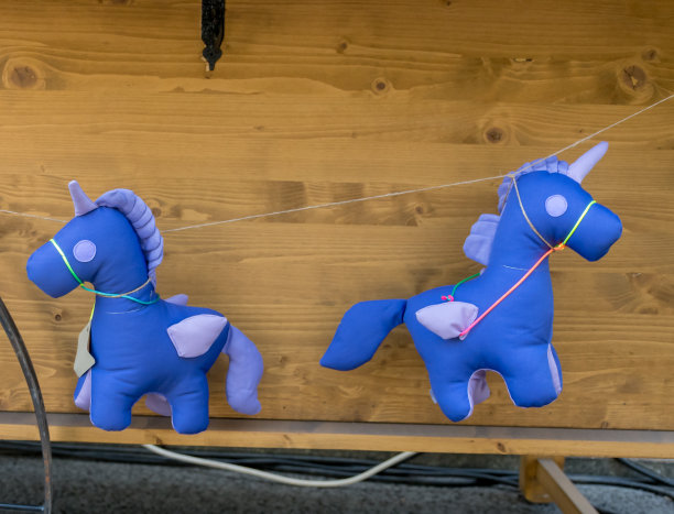 在美食节期间，紫色的独角兽玩具挂在一辆货车的绳子上图片下载