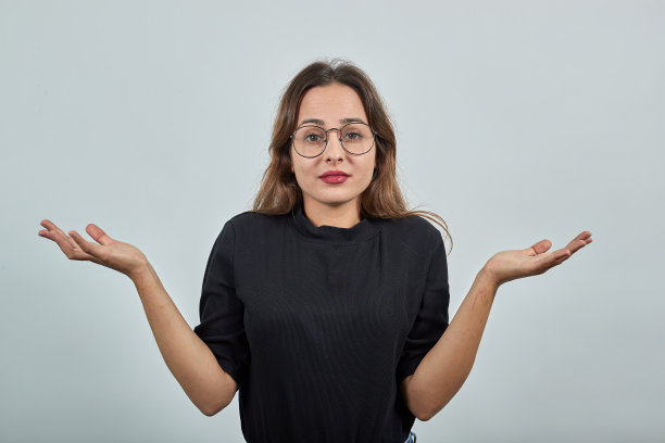 戴眼镜的困惑女孩惊奇地张开双手图片下载