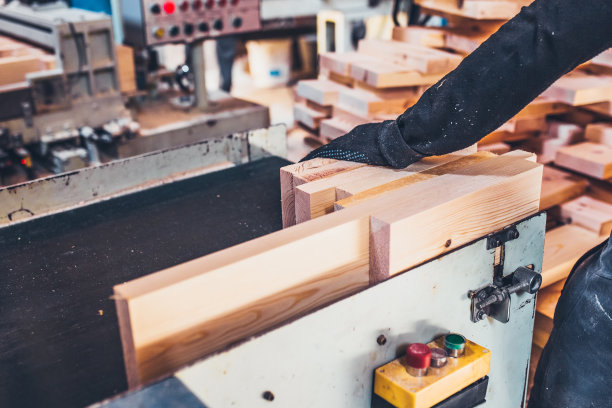 木工车间的工人手工将材料分类并提供给机器图片下载